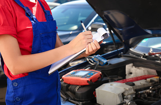 Mechanic in Red Shirt and Blue Overalls, Inspecting a Car Engine — Argenton Automotive Repairs In Boolaroo, NSW