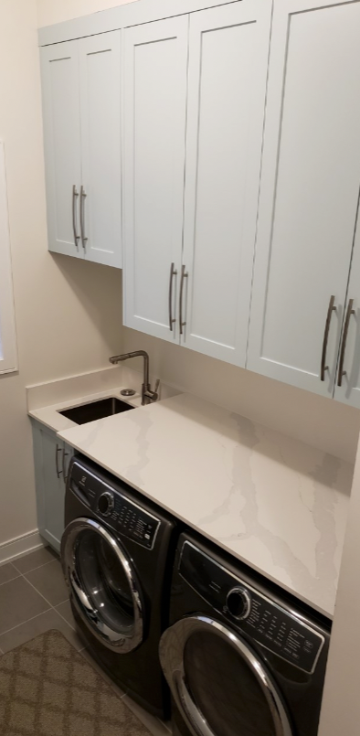A laundry room with a washer and dryer and a sink.