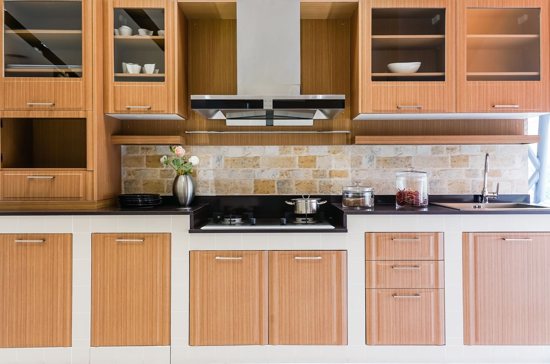 A kitchen with wooden cabinets and a stove top oven.