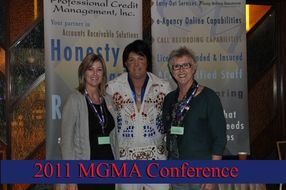 Three people posing at the 2011 MGMA Conference in front of a “Honesty” poster backdrop