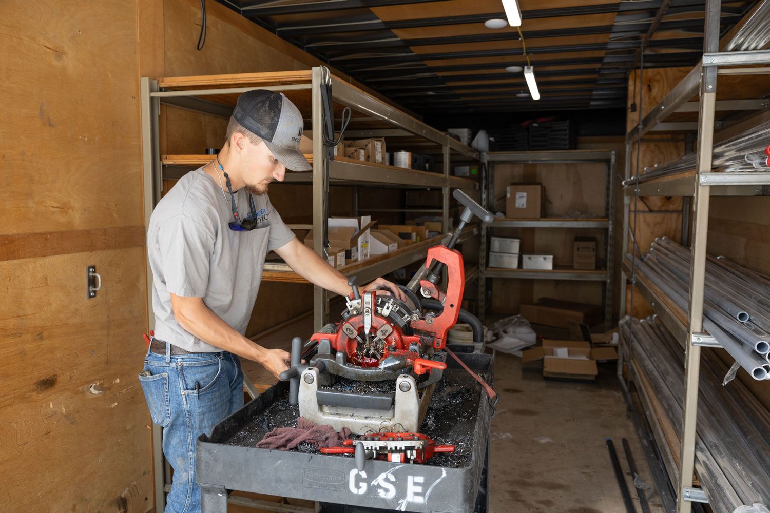 A man is working on a machine in a warehouse.