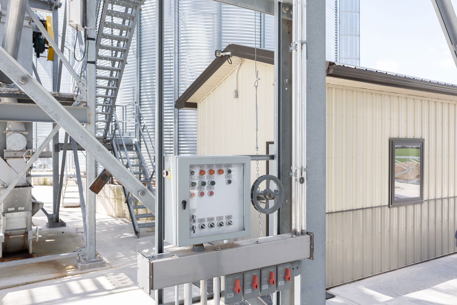 A building with a staircase and a control panel in front of it.