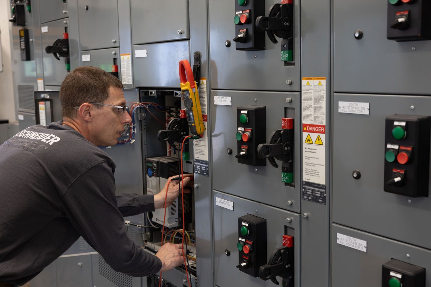 A man is working on an electrical panel in a room