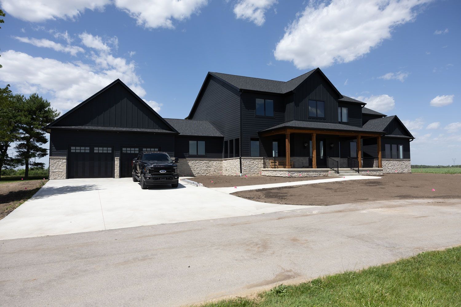 A black truck is parked in front of a large house