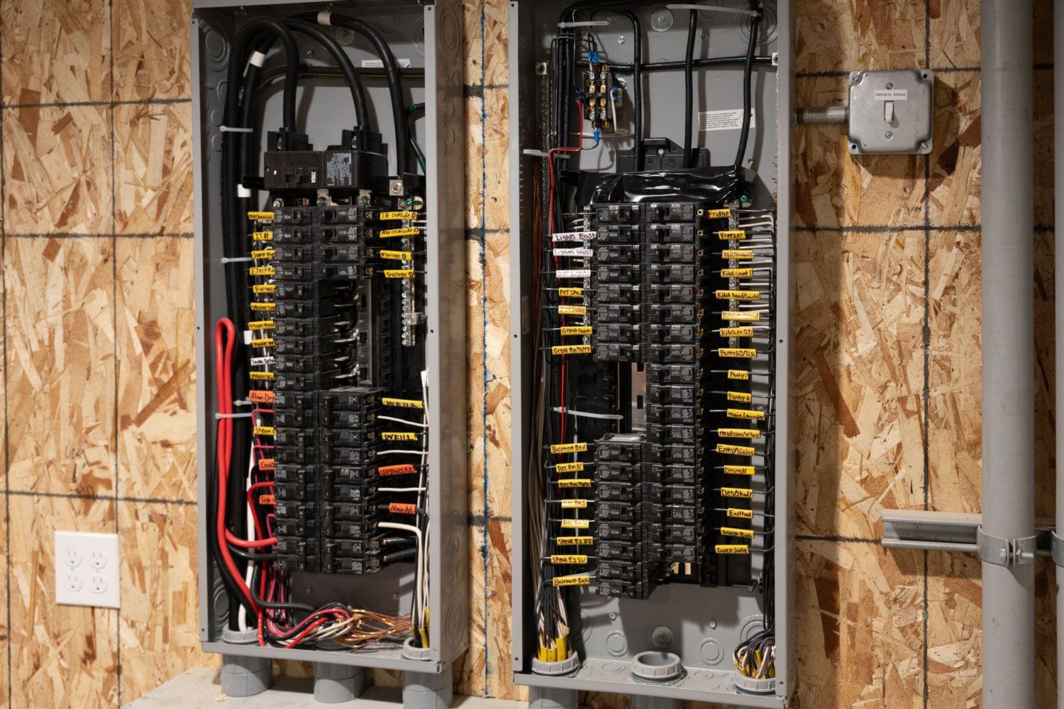 Two electrical boxes are sitting next to each other on a wall.
