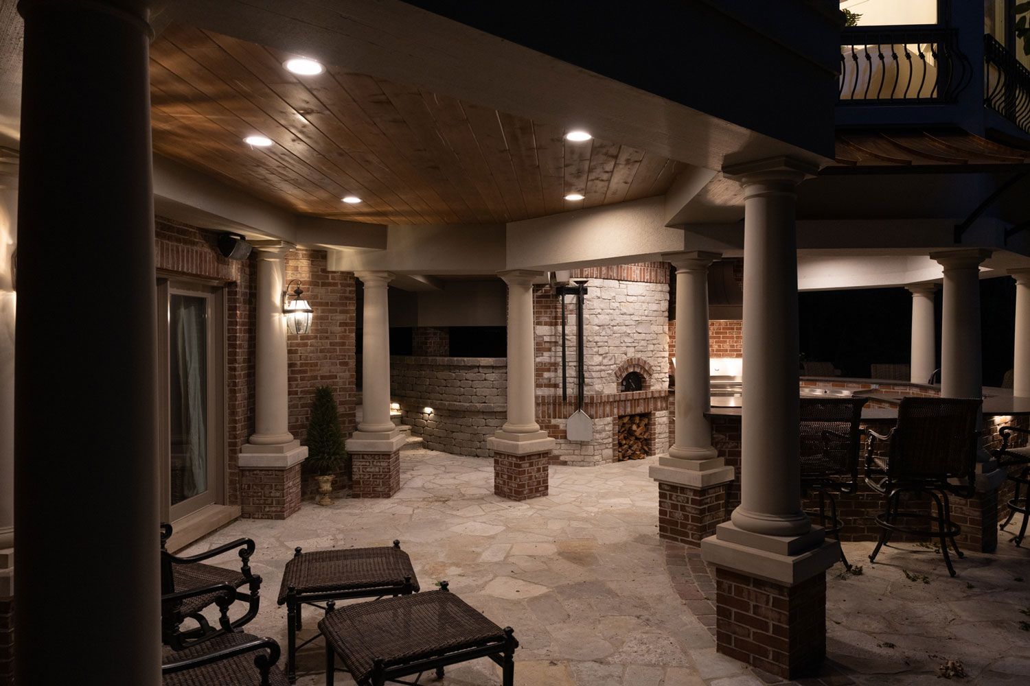 A patio area with columns and chairs at night