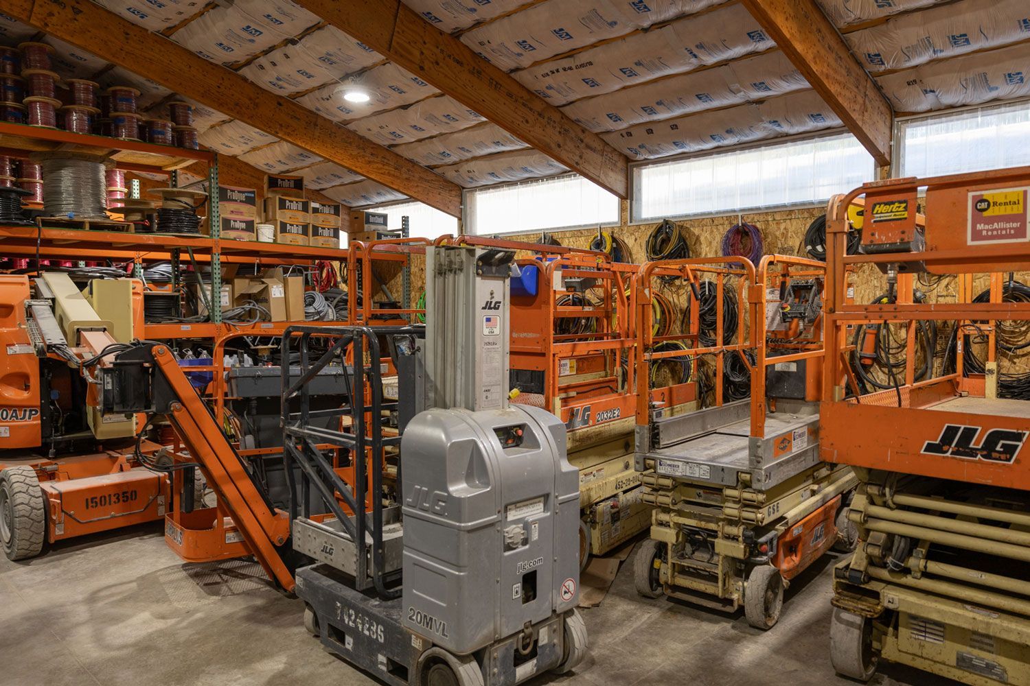 A warehouse filled with lots of jlg aerial lifts.
