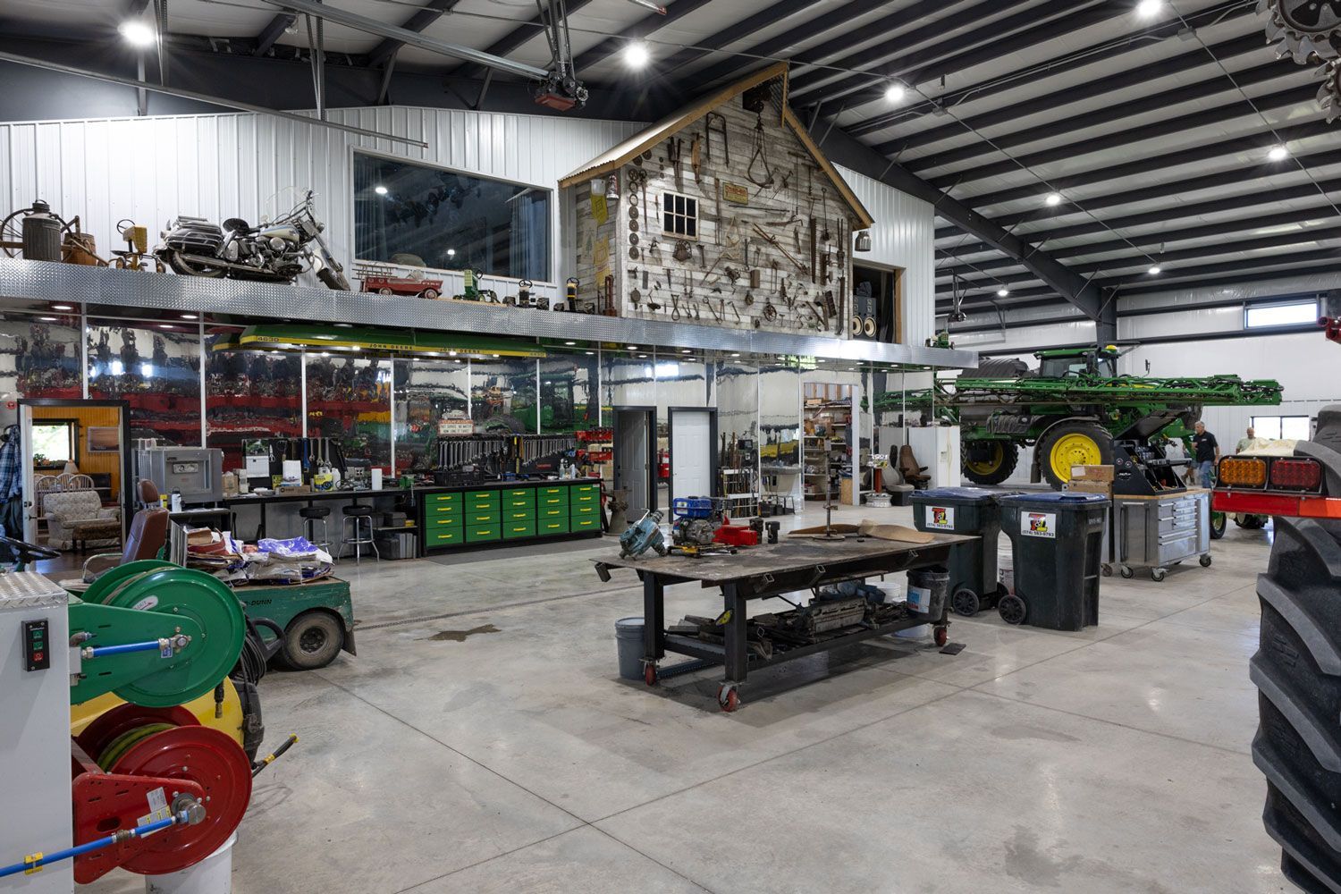 A large warehouse filled with lots of tractors and machinery.