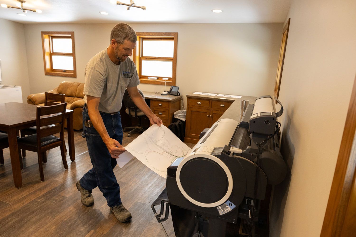 A man is standing in a room holding a piece of paper.