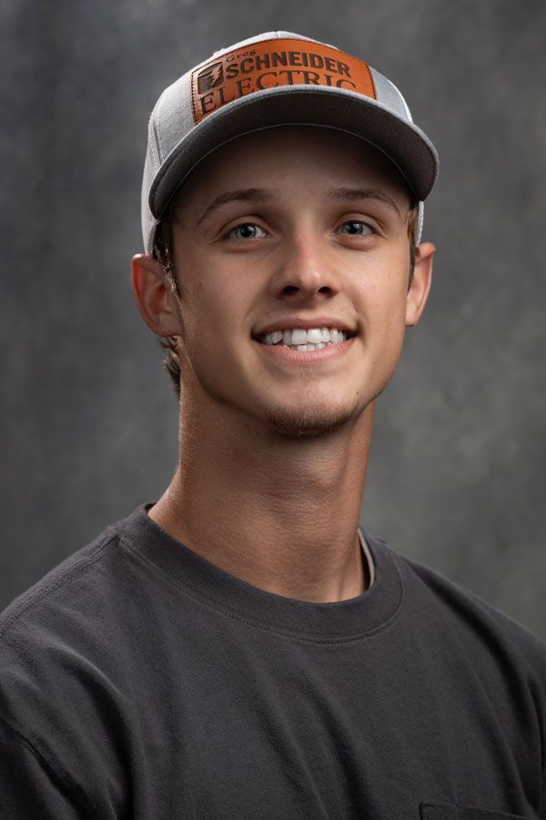 A young man wearing a hat and smiling for the camera.