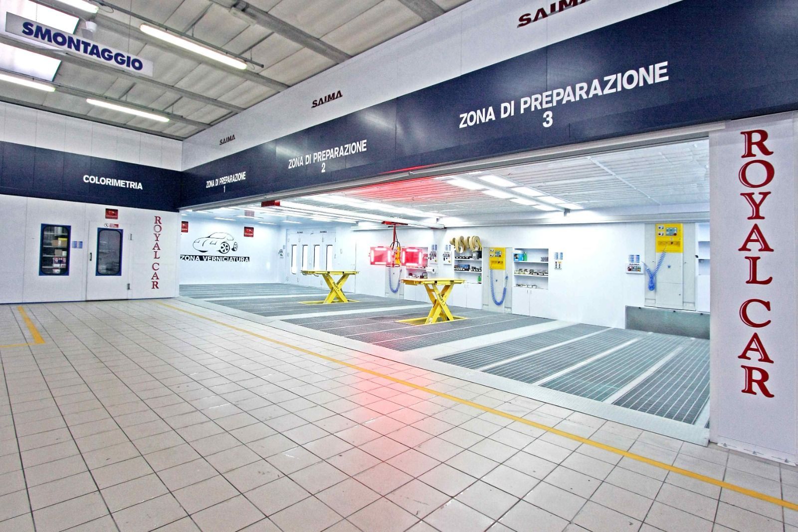 Pista da sci al coperto e showroom con pannelli blu sul soffitto, pavimento piastrellato e insegna rossa Royalcar.