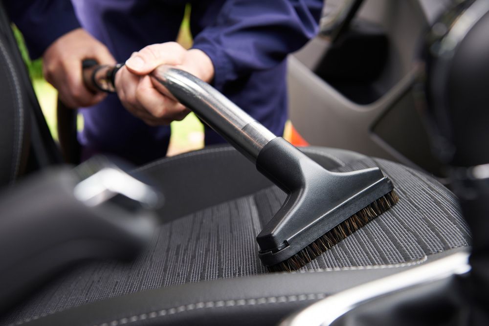 A Person Is Cleaning The Seats Of A Car With A Vacuum Cleaner — Mr Steam Clean Tweed Coast In Banora Point, NSW
