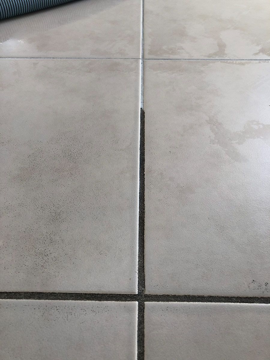 A Close Up Of A Tiled Floor With A Black Line Between The Tiles — Mr Steam Clean Tweed Coast In Banora Point, NSW