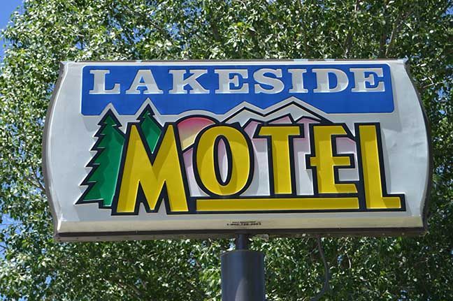 Lakeside Motel sign with blue and yellow lettering against trees