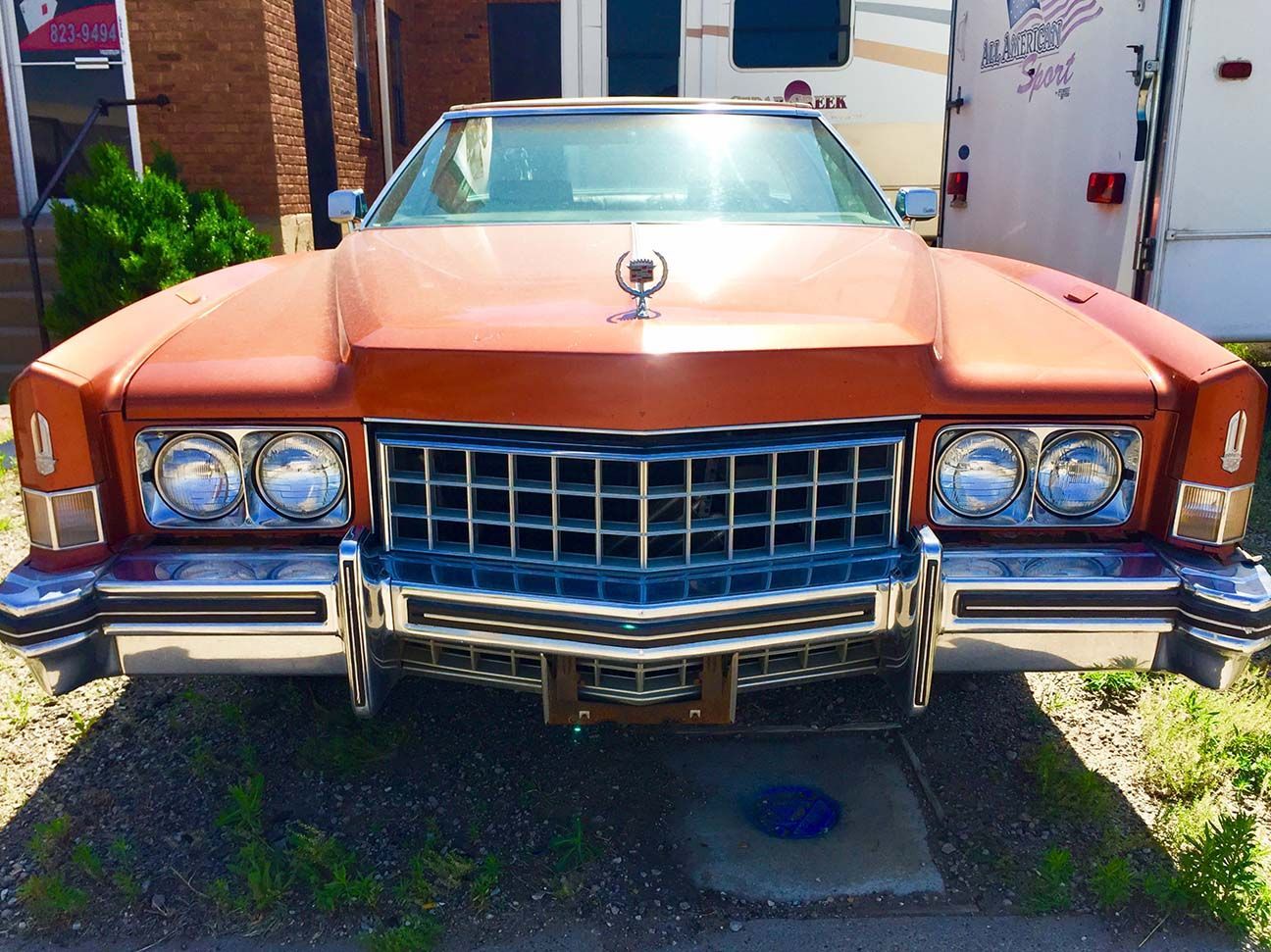 Front view of a copper vintage car parked outdoors in front of a building, El Dorado, Salina, Kansas