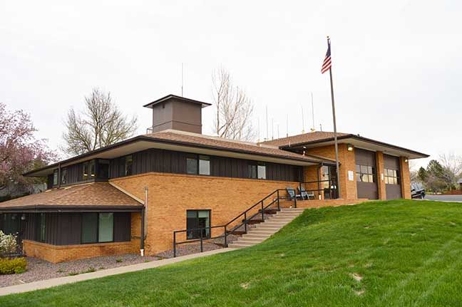 Low brick building on a grassy hill with an American flag and stairs leading to the entrance
