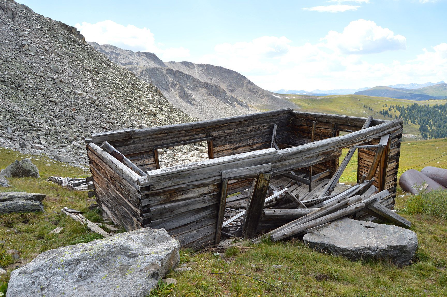Old wooden mining cart in a rocky mountain landscape with hills and open sky, Mayflower Gulch, Colorado