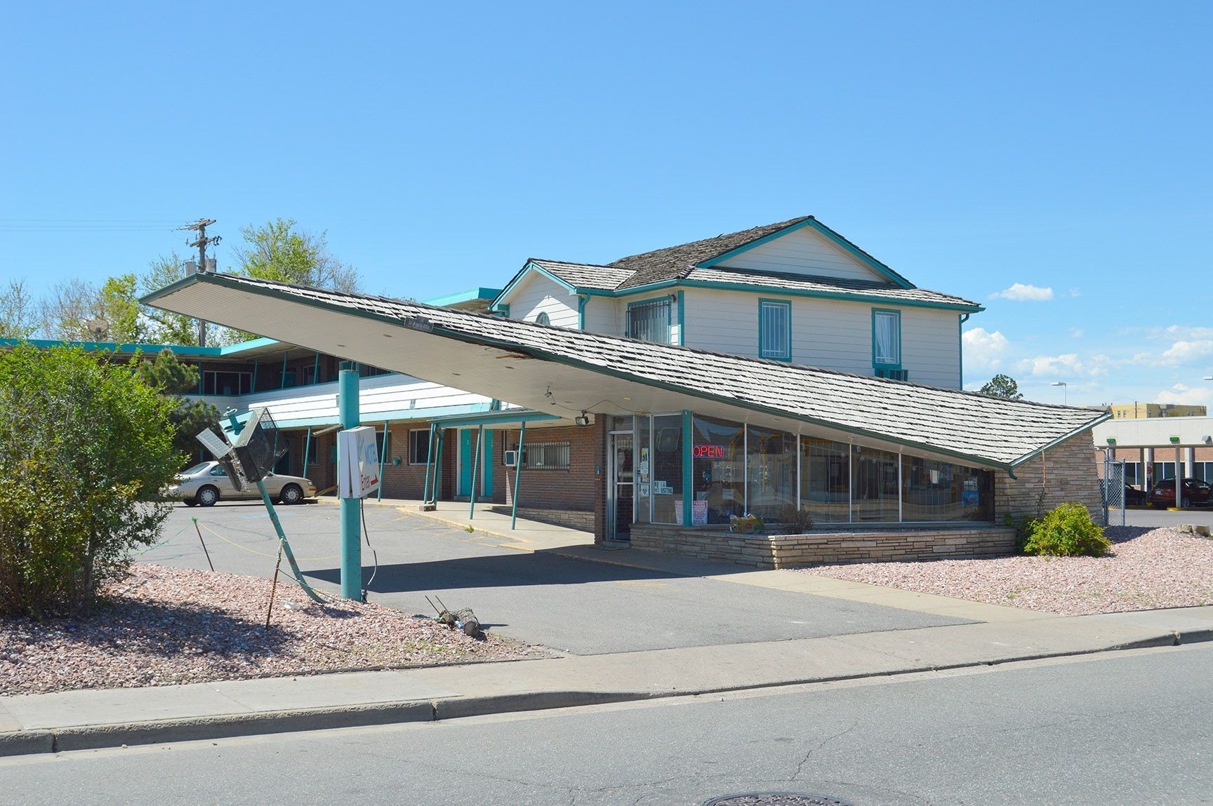Covered parking area beside a beige building under a clear blue sky