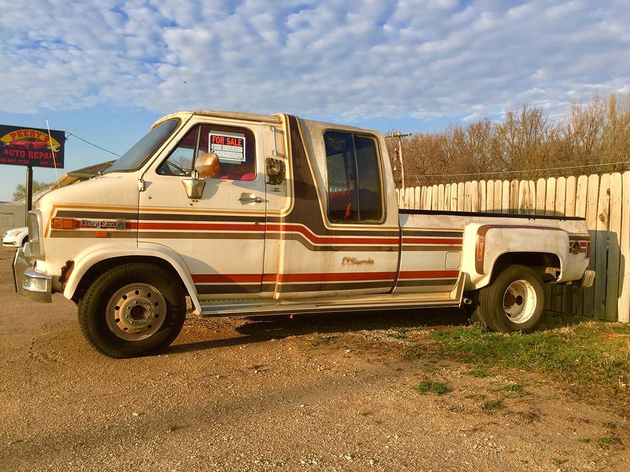 White pickup truck with brown stripes parked on gravel beside a wooden fence under a blue sky, Van/Truck hybrid, Chevrolet vruck, Salina, Kansas