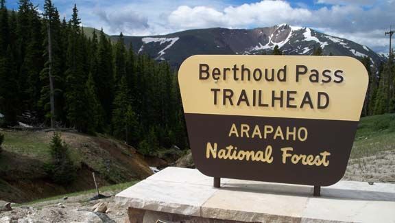 Berthoud Pass trailhead sign in Arapaho National Forest with mountain backdrop
