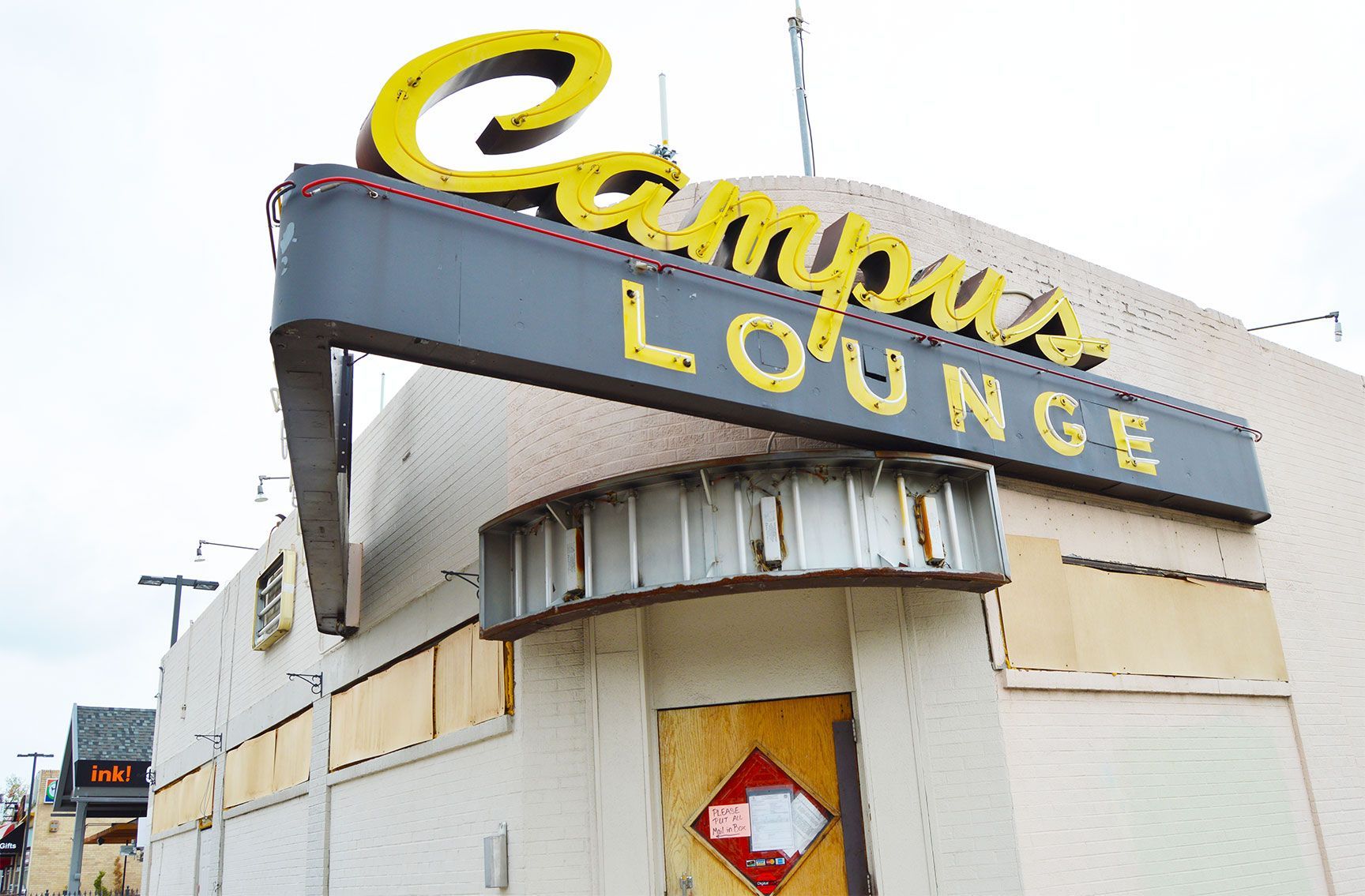 Exterior of Campus Lounge with a yellow sign on a weathered building, Denver, Colorado, Bonnie Brae neighborhood