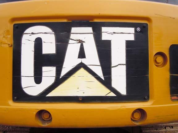 Close-up of a yellow Caterpillar CAT logo on a vehicle front grille