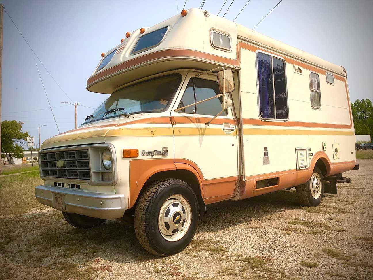 Cream and orange vintage camper van parked on gravel under a clear sky, Salina, Kansas