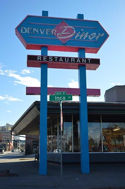 Denver Diner sign on a blue pole outside the restaurant under a clear sky