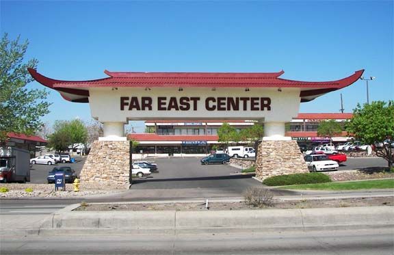 Far East Center entrance arch with red roof over a parking lot and roadway
