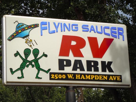 Flying Saucer RV Park sign with cartoon UFO, aliens, and address 2500 W. Hampden Ave.