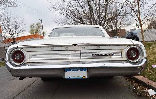 Rear view of a white classic car parked on a street on a cloudy day, Ford Galaxie, Five Points neighborhood, Denver, Colorado