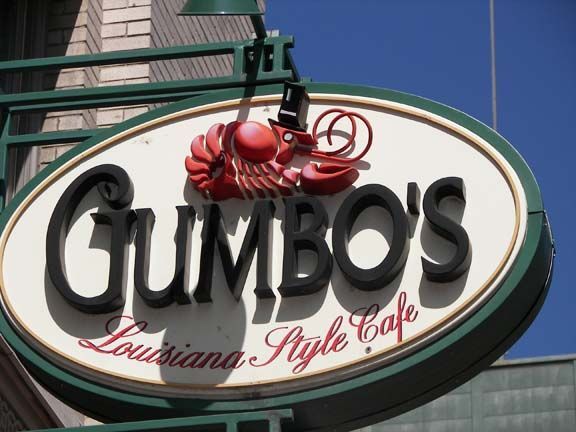 Gumbo’s Louisiana-style cafe sign with a red crawfish atop an oval white and green plaque