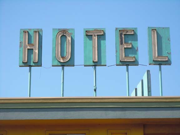 Vintage HOTEL sign on a rooftop against a clear blue sky