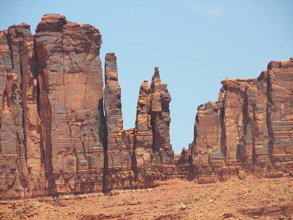 Red sandstone rock formations in a desert under a clear blue sky.