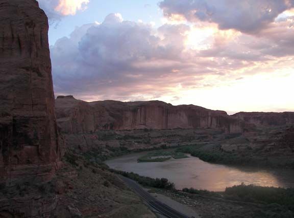 Sunset over a river bend with red canyon cliffs and cloudy sky