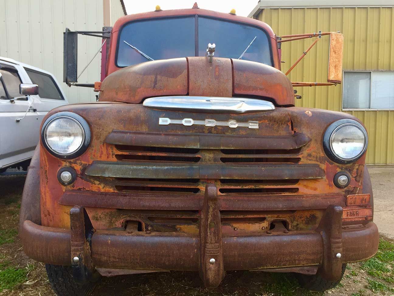 Rusty vintage truck parked in front of a warehouse, front view. Dodge truck, Salina, Kansas