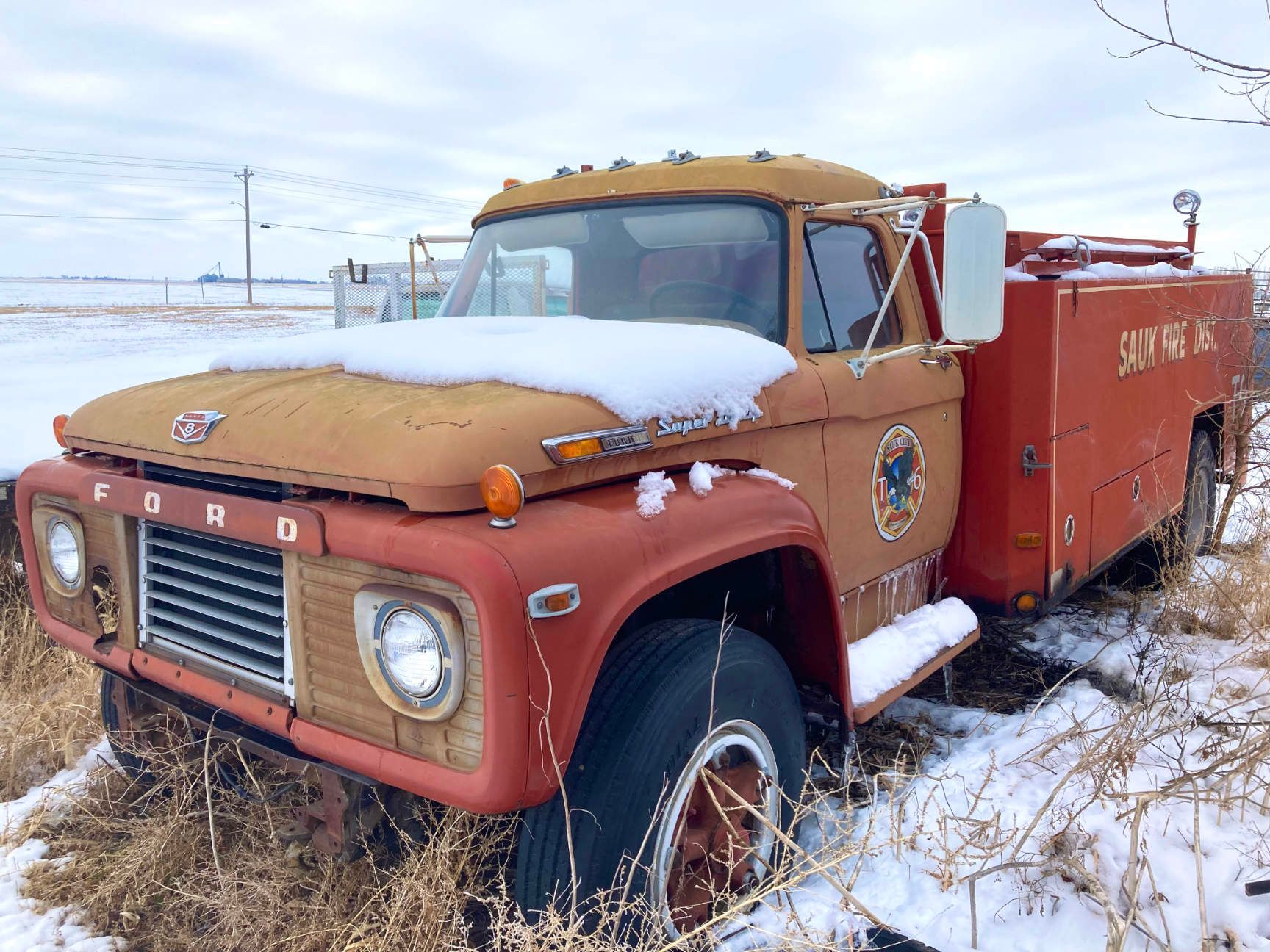Snow-covered red vintage Ford truck parked in a snowy field, York, Nebraska