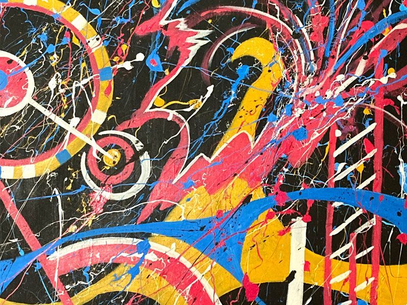 Abstract painting with bright pink, blue, yellow, and white paint splatters and swirling shapes on a black background