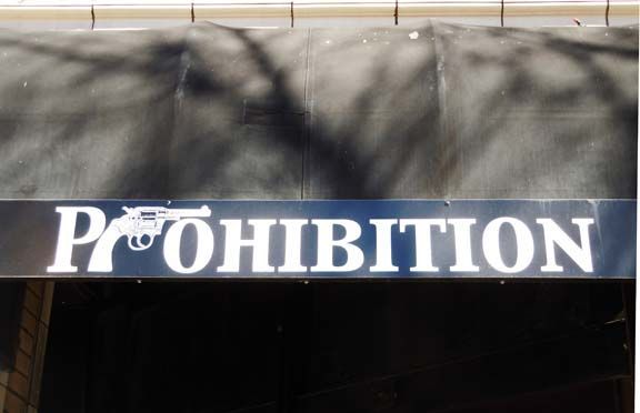 Prohibition sign in white letters on a dark banner above an entrance