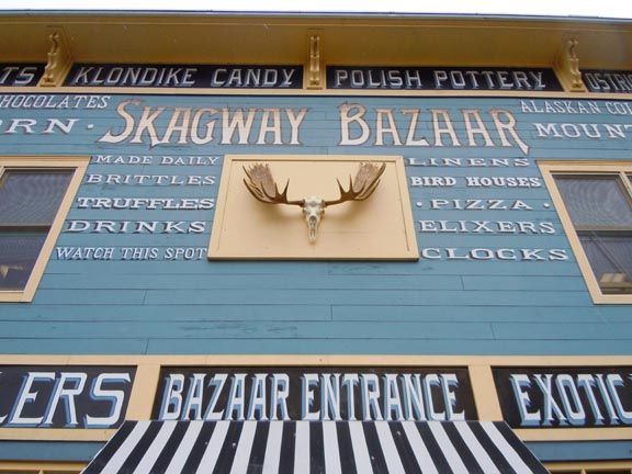 Blue Skagway Bazaar storefront with sign and mounted antlers above the entrance