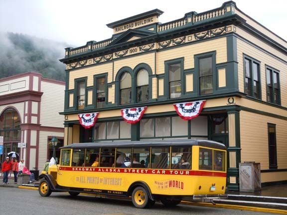 Yellow trolley bus in front of a historic two-story building with red, white, and blue bunting