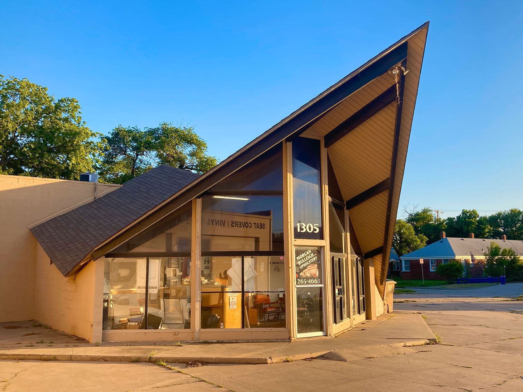 Modern building with a steep triangular roof and glass facade in warm sunlight