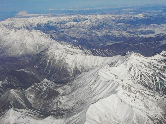Snow-covered mountain range with rugged ridges and valleys under a clear sky