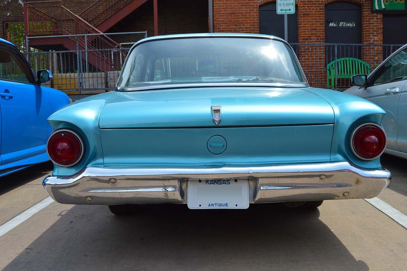 Rear view of a light blue classic car parked outdoors with chrome bumper and red taillights, Wichita, Kansas