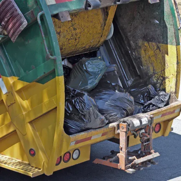 A picture showing a dump truck with spilled load on the road.