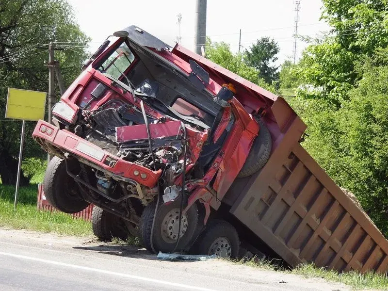 An image showing a dump truck accident with legal services assistance.