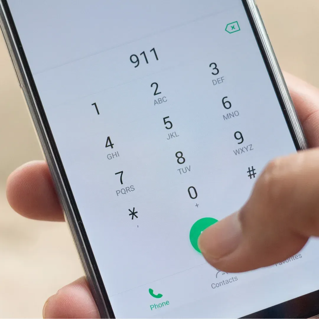 An image showing a person calling 911 while another person is being helped to safety.