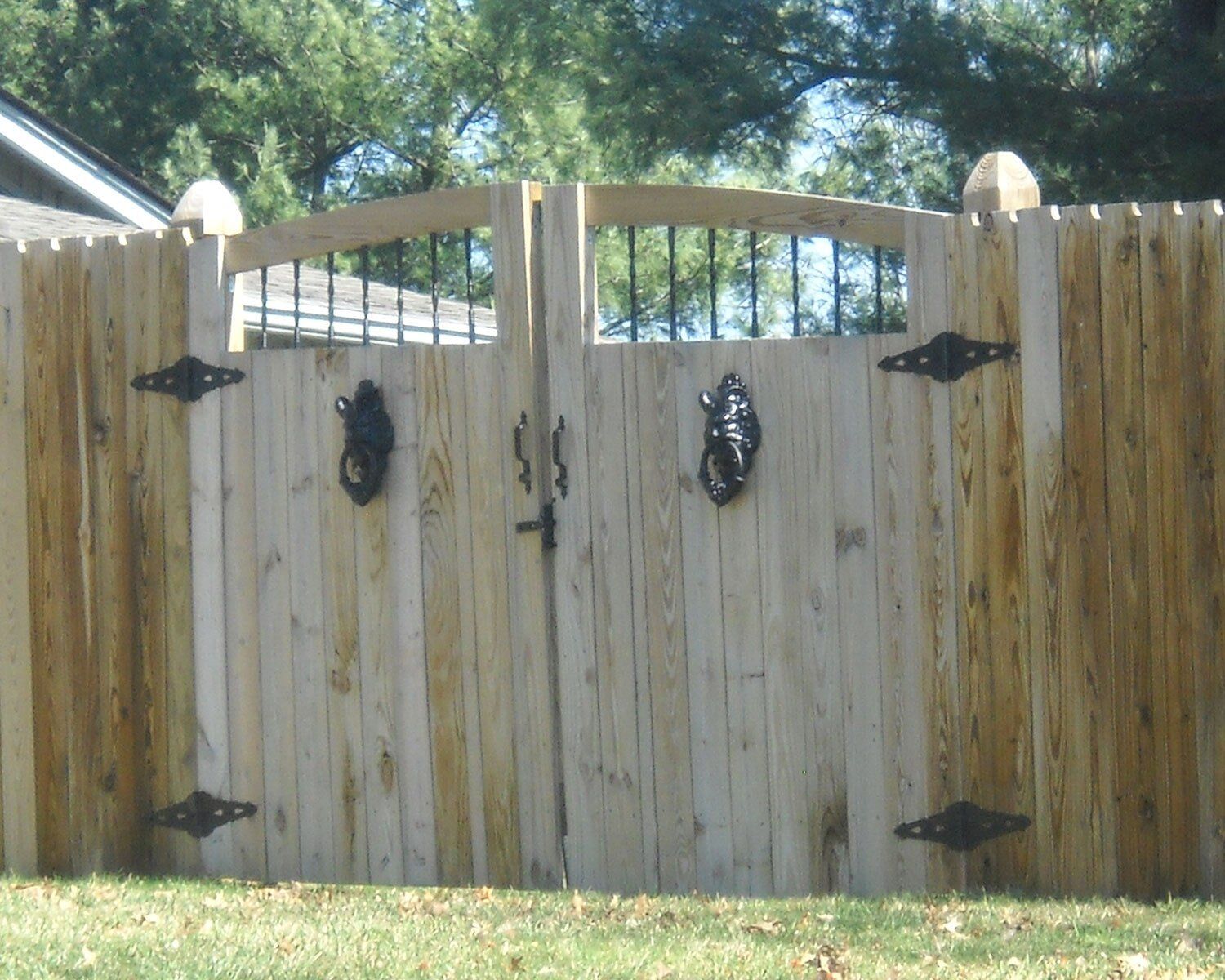 A wooden fence with a gate in the middle of it A wooden fence with a gate in the middle of it
