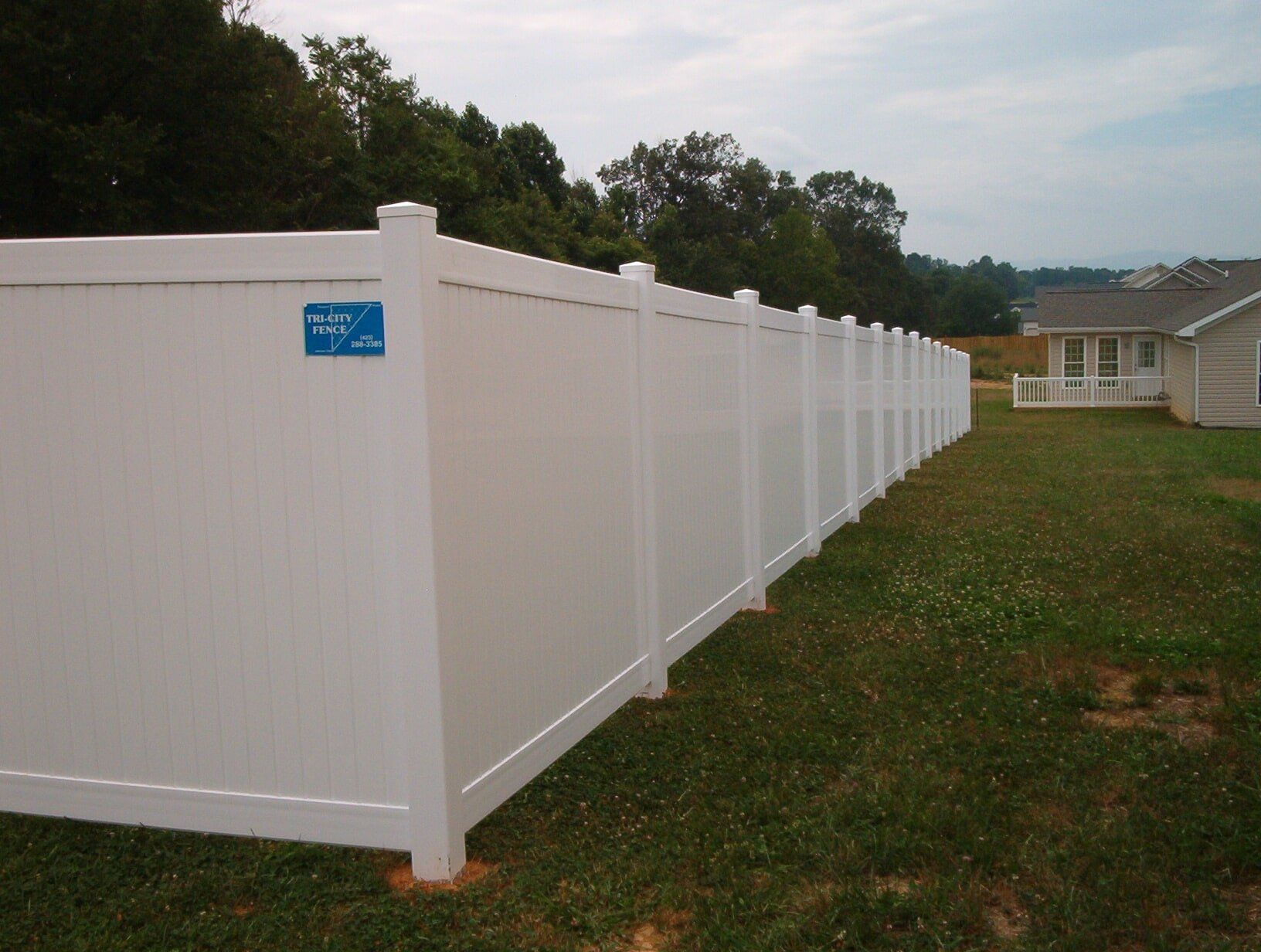 A white fence with a blue sticker on it
