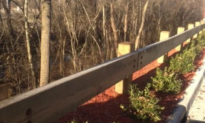 A wooden fence surrounds a lush green forest.